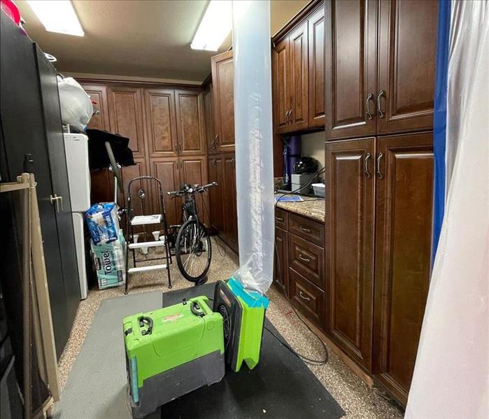 Drying equipment forcing air into a ceiling cavity in a partially sealed storage room