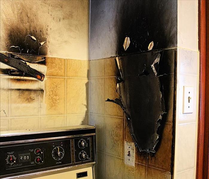 fire damaged wall by kitchen range